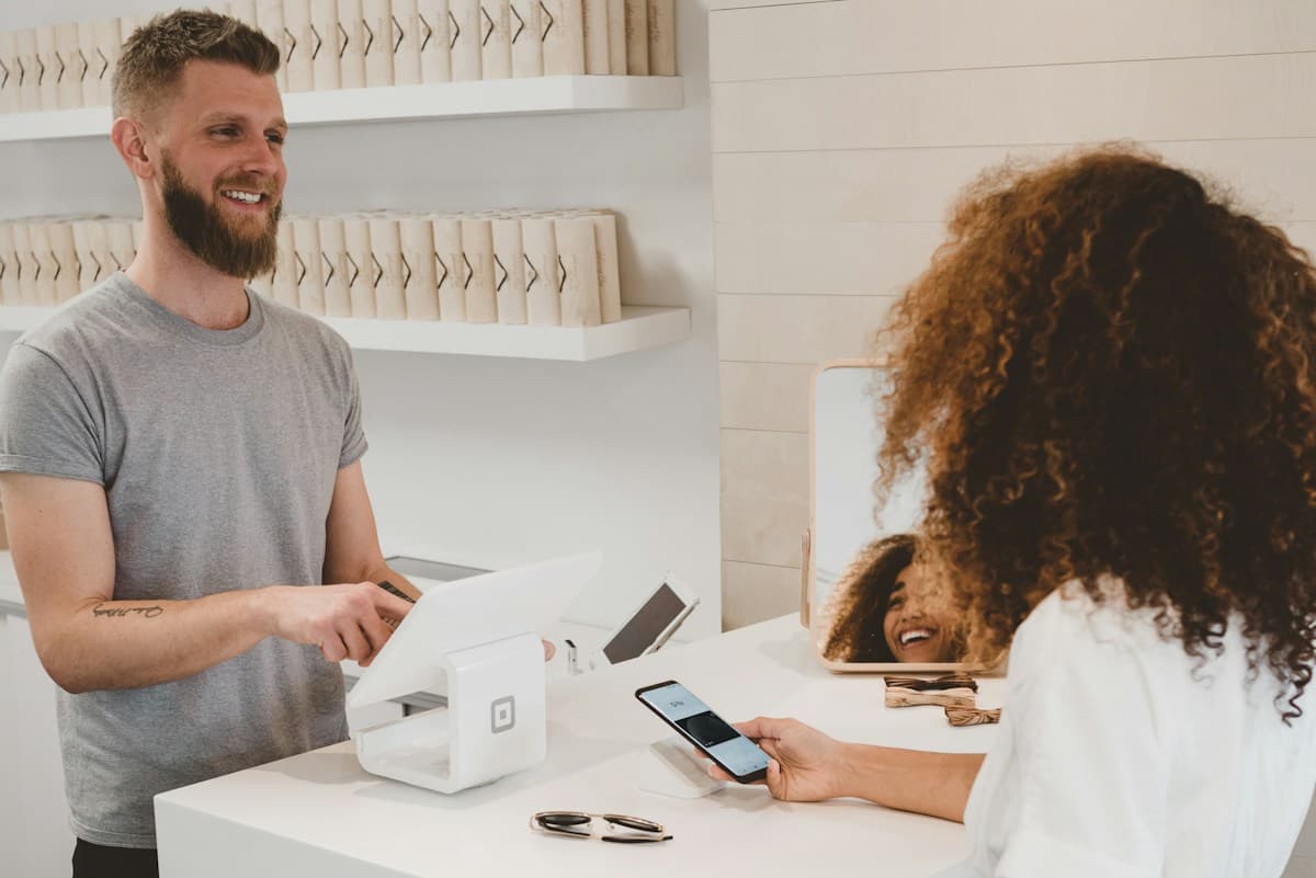Clienta pagando con el celular en el mostrador de un comercio